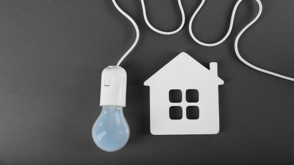 Tips to protect your property | a light bulb next to a house made from a coaster.